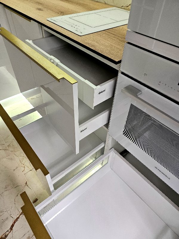 Выдвинутые ящики Blum в нижних шкафах кухни рядом с духовым шкафом